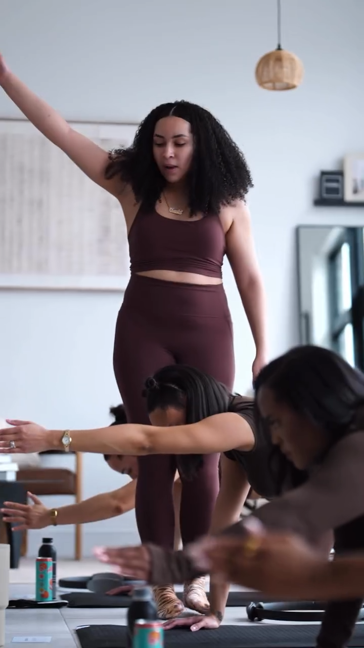 Chantel Monegro coaching a small group on Pilates reformers in a warm-toned studio